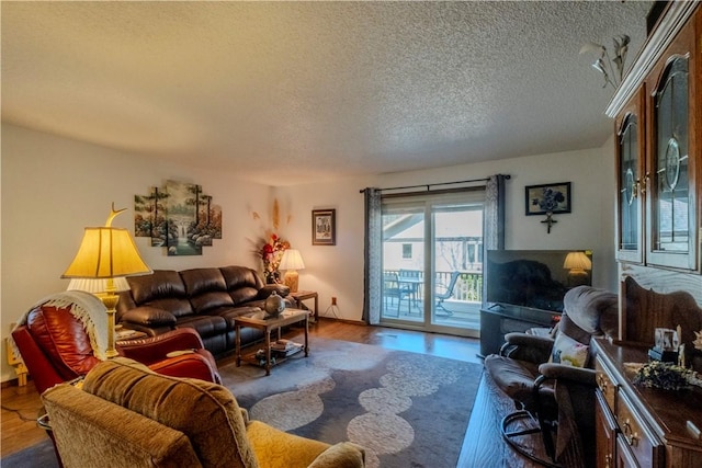 living room with a textured ceiling and wood finished floors