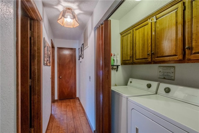 laundry area with cabinet space, washer and dryer, light wood finished floors, and baseboards