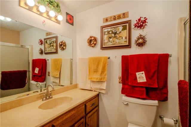 bathroom featuring an enclosed shower, toilet, and vanity