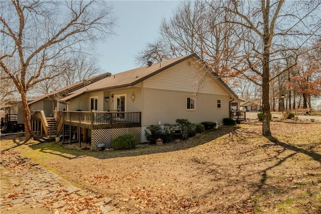 view of home's exterior featuring stairway and a deck