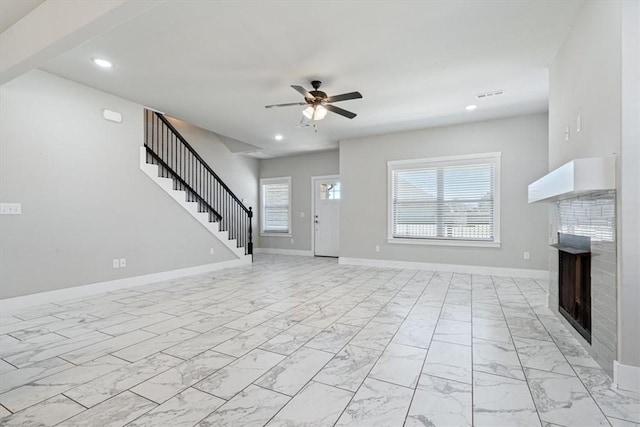 unfurnished living room featuring marble finish floor, recessed lighting, a fireplace, baseboards, and stairs