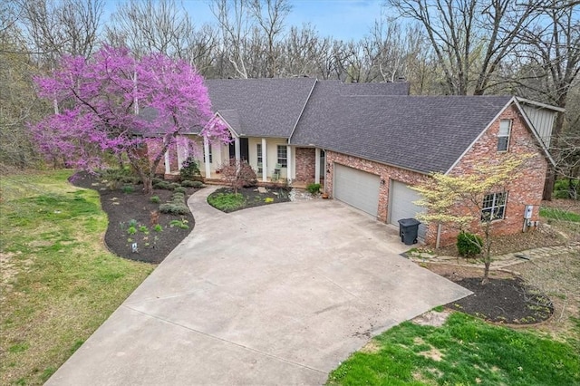 view of front of property with brick siding, a front lawn, roof with shingles, a garage, and driveway