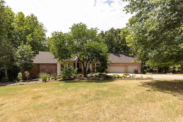 view of front of home featuring a front yard, brick siding, and driveway