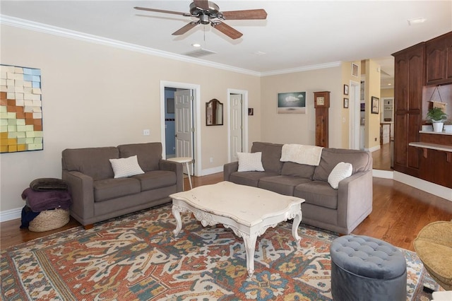 living area with ornamental molding, baseboards, and wood finished floors