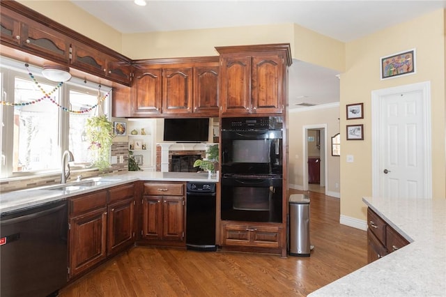 kitchen featuring dark wood finished floors, dishwasher, dobule oven black, and a sink