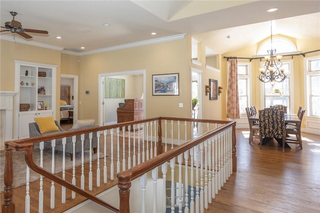 hall with vaulted ceiling, ornamental molding, an upstairs landing, wood finished floors, and a notable chandelier