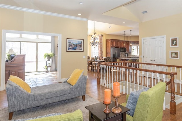 living area with visible vents, a notable chandelier, recessed lighting, crown molding, and baseboards