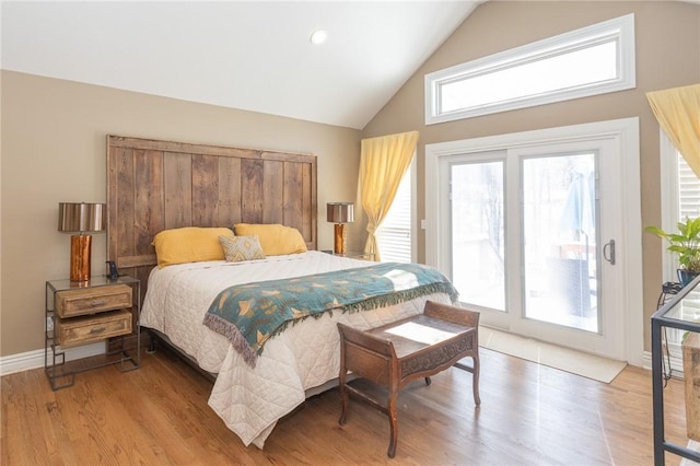 bedroom featuring baseboards, high vaulted ceiling, wood finished floors, and access to outside