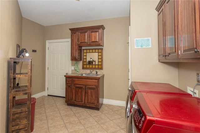 washroom with baseboards, light tile patterned floors, cabinet space, independent washer and dryer, and a sink