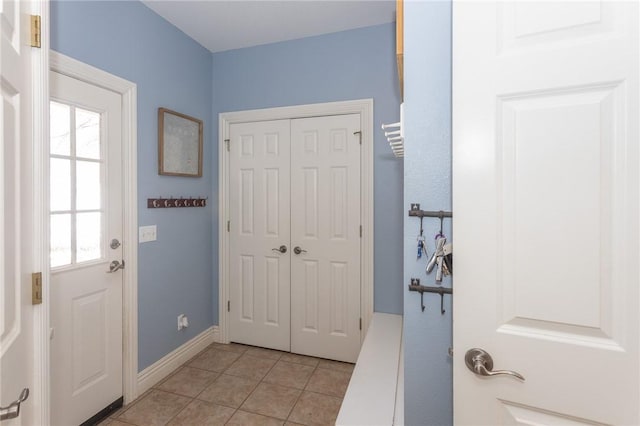 entryway featuring light tile patterned flooring and baseboards