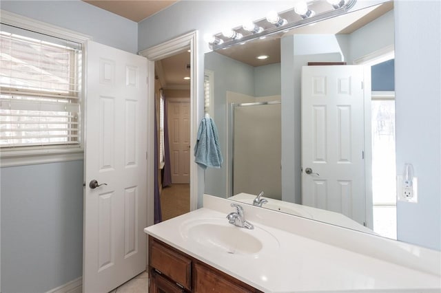 full bath with vanity, a healthy amount of sunlight, and a shower stall