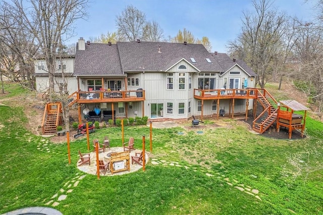 rear view of property with stairs, a wooden deck, a patio area, and an outdoor fire pit