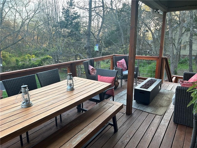 deck featuring outdoor dining space and an outdoor fire pit