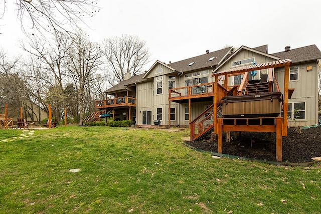 rear view of house featuring a lawn, a wooden deck, and stairs