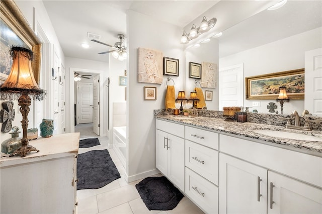 bathroom featuring tile patterned flooring, ceiling fan, baseboards, double vanity, and a sink