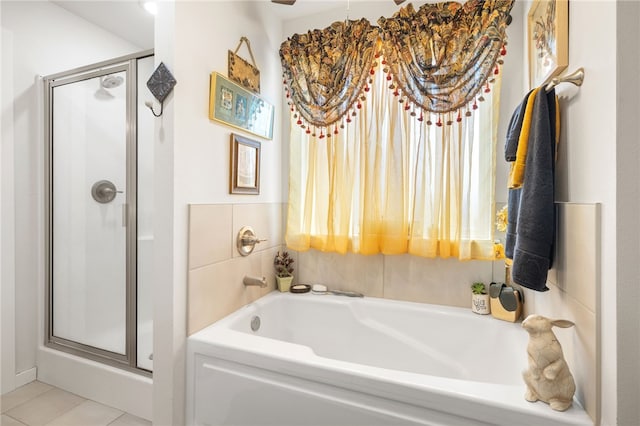 bathroom featuring a bath, tile patterned flooring, and a stall shower