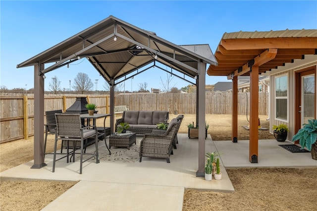 view of patio with a gazebo, an outdoor living space, and a fenced backyard