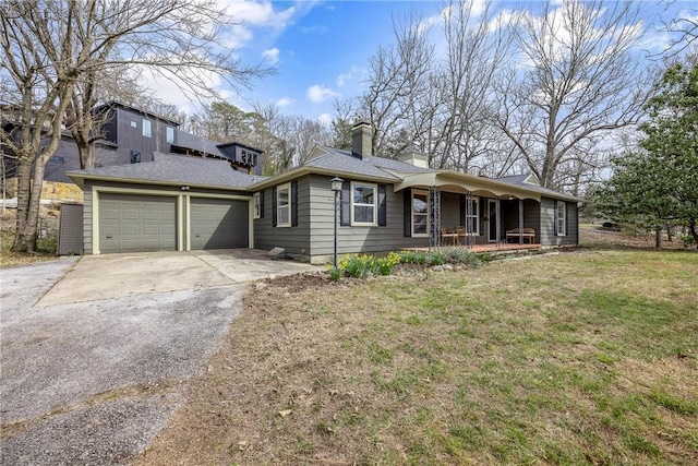 view of front of house featuring a front lawn, concrete driveway, covered porch, a chimney, and a garage