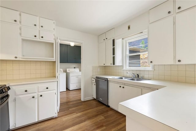 kitchen featuring washing machine and dryer, dishwasher, decorative backsplash, wood finished floors, and a sink