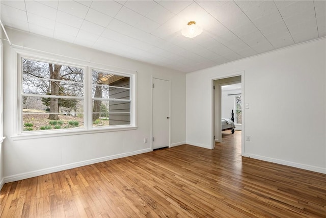 spare room featuring baseboards and light wood-style flooring