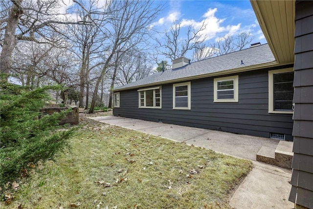 view of property exterior featuring a yard and a chimney