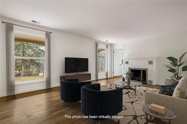 living room with visible vents, baseboards, light wood-style flooring, and a fireplace