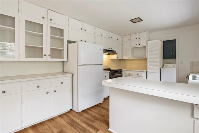 kitchen with washer / dryer, freestanding refrigerator, black electric range, under cabinet range hood, and white cabinetry