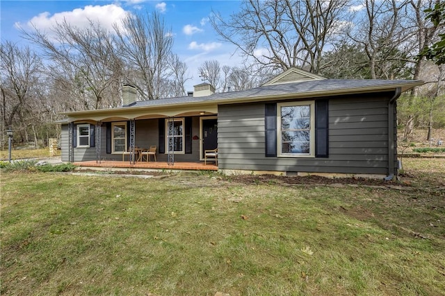 ranch-style home with a front lawn, covered porch, and a chimney