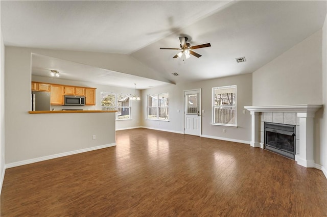 unfurnished living room featuring dark wood-style floors, baseboards, a fireplace, ceiling fan, and vaulted ceiling