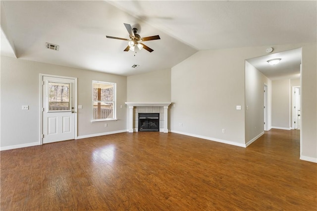 unfurnished living room featuring visible vents, wood finished floors, a fireplace, ceiling fan, and vaulted ceiling