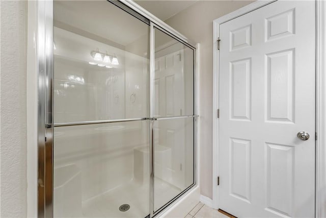 bathroom with tile patterned flooring and a shower stall