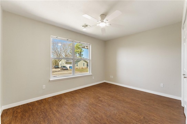 empty room featuring visible vents, a ceiling fan, baseboards, and dark wood-style flooring