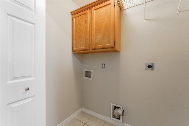 washroom featuring baseboards, washer hookup, light tile patterned floors, cabinet space, and electric dryer hookup