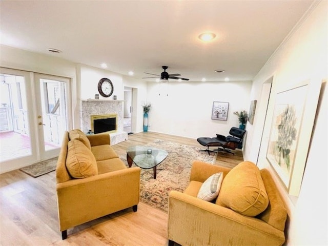 living room with recessed lighting, a ceiling fan, a fireplace, and light wood finished floors