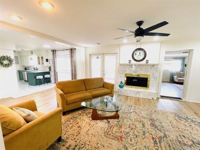 living room featuring ceiling fan, french doors, wood finished floors, and a high end fireplace