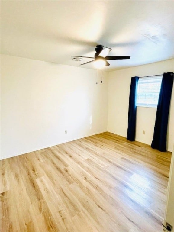 empty room featuring light wood-type flooring and a ceiling fan