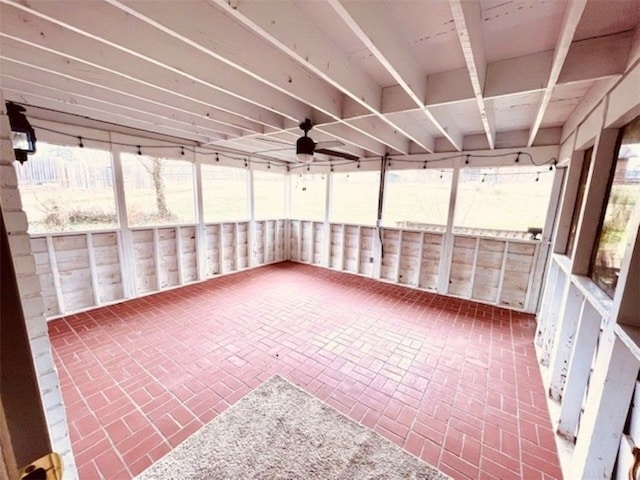 unfurnished sunroom featuring a ceiling fan