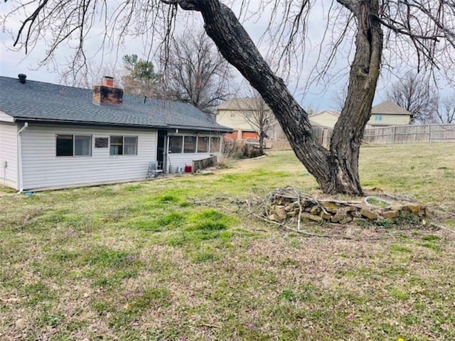 view of yard featuring a sunroom and fence