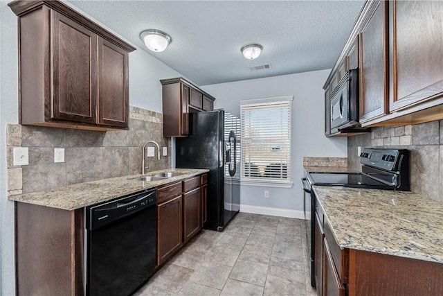 kitchen featuring visible vents, black appliances, a sink, dark brown cabinetry, and baseboards