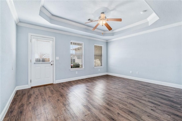 unfurnished room with a tray ceiling, dark wood-style floors, crown molding, baseboards, and ceiling fan