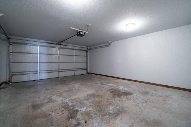 garage featuring a garage door opener and baseboards