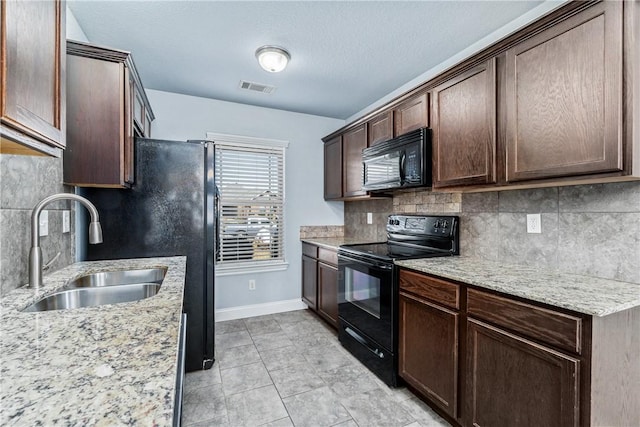 kitchen featuring visible vents, dark brown cabinets, baseboards, black appliances, and a sink