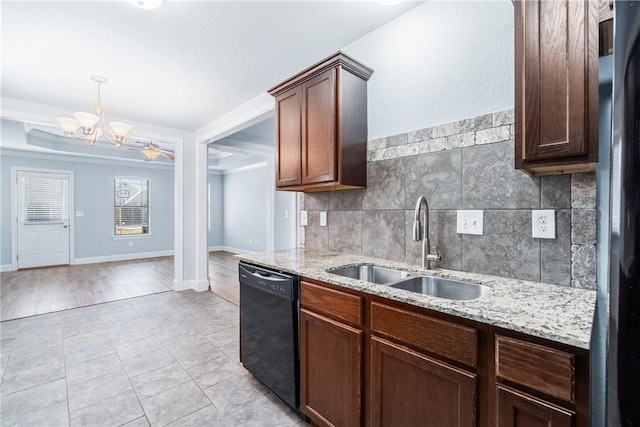 kitchen with light stone countertops, black dishwasher, decorative backsplash, freestanding refrigerator, and a sink