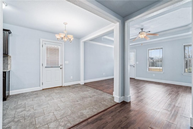 foyer featuring ceiling fan with notable chandelier, dark wood-type flooring, and baseboards