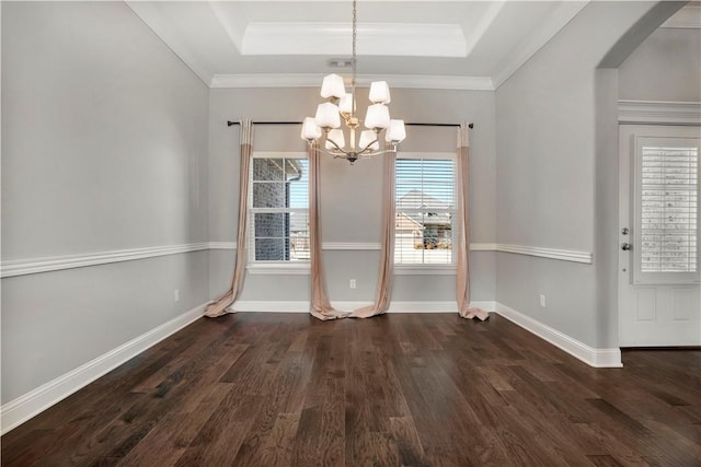 unfurnished dining area featuring a tray ceiling, arched walkways, baseboards, and dark wood-style flooring