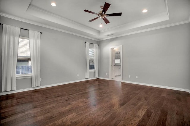 spare room with ornamental molding, a tray ceiling, and wood finished floors