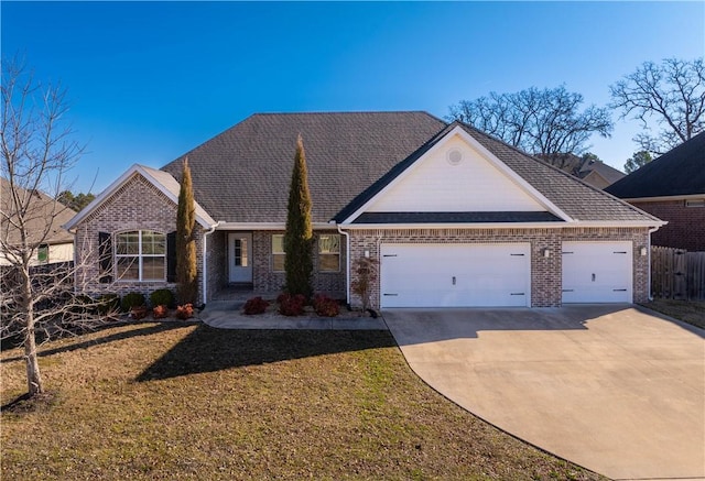 view of front facade with a front yard, fence, driveway, a garage, and brick siding