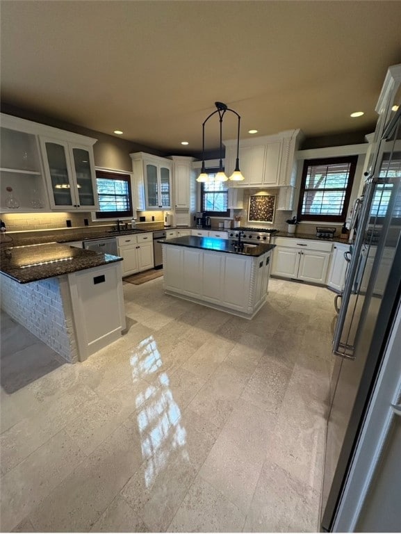 kitchen featuring glass insert cabinets, a healthy amount of sunlight, and white cabinets