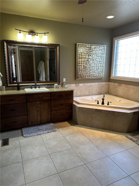 full bathroom featuring tile patterned floors, a bath, and vanity