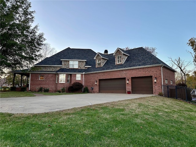 view of front of property featuring brick siding, a front lawn, fence, a garage, and driveway